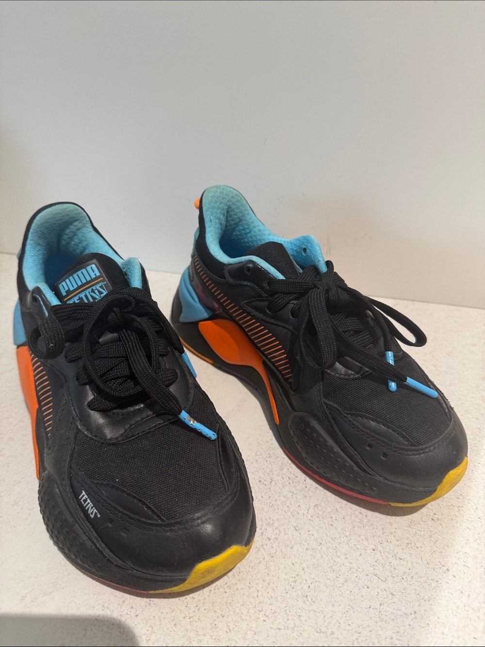 Puma Kids Black Sneakers with Blue Lining and Orange Accents